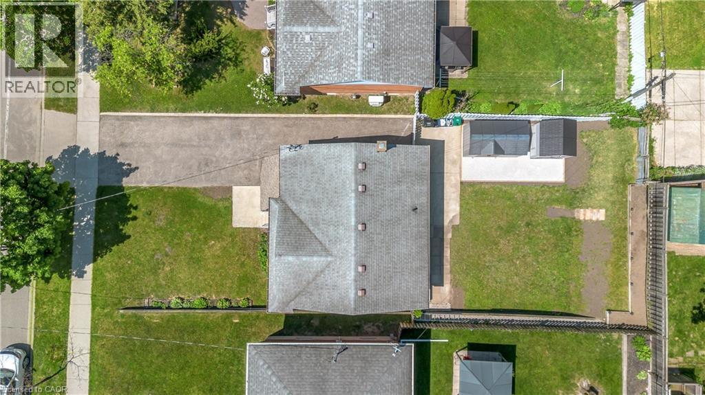 Expansive property with a central residence featuring a grey shingle roof and multiple skylights - 450 Highland Road E, Kitchener, ON