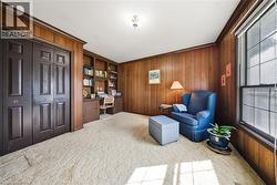 Wood-paneled walls with built-in shelving, desk, and storage cabinetry - 