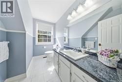Spacious vanity with an integrated rectangular sink, dark patterned countertop, and undermount cabinetry - 
