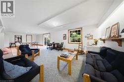 Expansive lower level with light-colored carpeting and wood-finish flooring - 