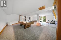 Expansive finished lower level featuring carpeted flooring, wood trim, white panel doors, and sliding glass doors to the exterior - 