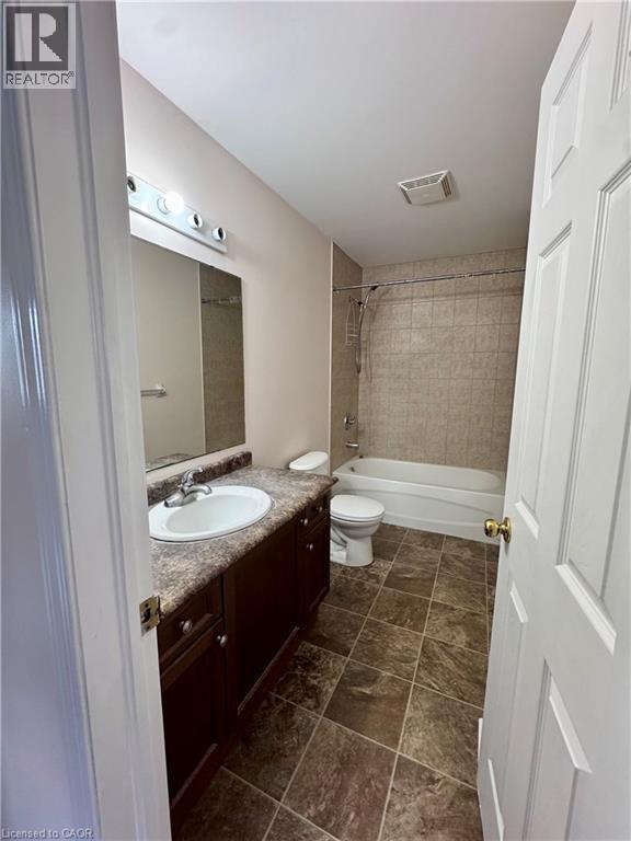 Full bathroom with a dark wood-finish vanity, integrated sink, and laminate countertop - 452 Beaumont Crescent, Kitchener, ON