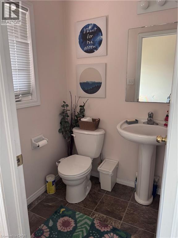 Bathroom featuring a pedestal sink, wall-mounted mirror, and tile flooring - 452 Beaumont Crescent, Kitchener, ON