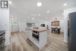 Kitchen island with wood-finish countertop and built-in microwave drawer - 