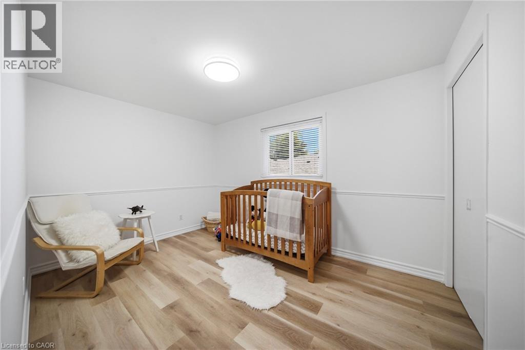 Bright room featuring vinyl flooring, white walls with wainscoting, and a ceiling-mounted light fixture - 2306 Devon Road, Oakville, ON
