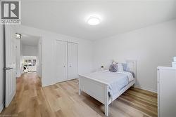 Bedroom featuring vinyl flooring, white walls, and a flush-mount ceiling light - 