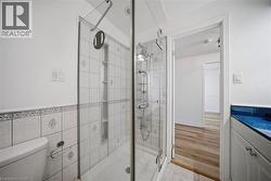Glass-enclosed shower with a multi-function shower system and integrated shelving - 