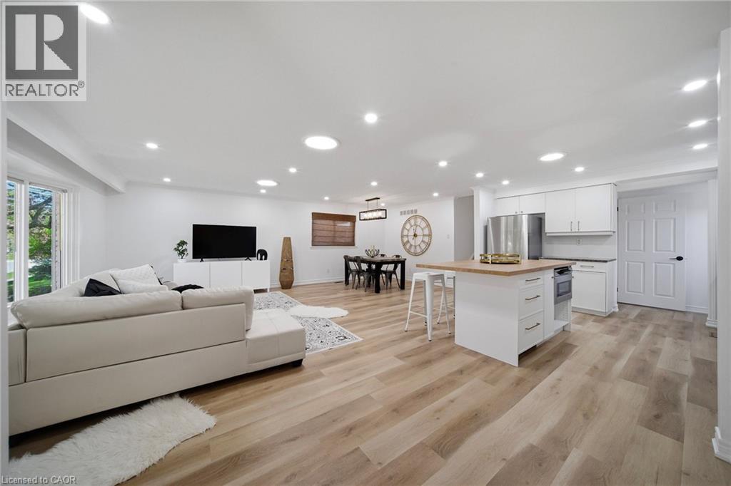 Open-concept living space featuring vinyl flooring, recessed lighting, and white walls - 2306 Devon Road, Oakville, ON