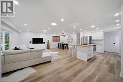 Open-concept living space featuring vinyl flooring, recessed lighting, and white walls - 