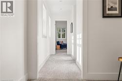 Recessed lighting, light gray textured carpeting, white trim, and white walls - 