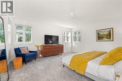Neutral wall color, wood-finish console, multiple windows, recessed lighting, and patterned carpeting - 
