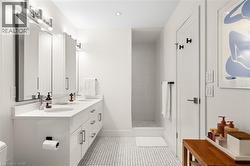 Double vanity with integrated sinks, contemporary chrome fixtures, and white cabinetry - 