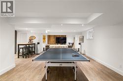 Wood-finish flooring, recessed ceiling lighting, light wall tones, and a window with white trim - 