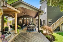 Expansive wood deck with a covered outdoor living area, featuring a sloped wood-paneled ceiling and ceiling fan - 