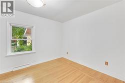Hardwood flooring, white painted walls, white trim, single window, flush mount ceiling fixture - 