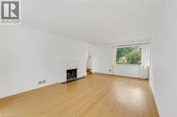Hardwood flooring, painted brick fireplace, crown molding, and a large window - 
