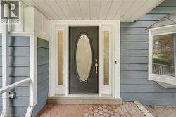 Entryway featuring a dark paneled door with an oval glass insert, flanked by two sidelight windows - 