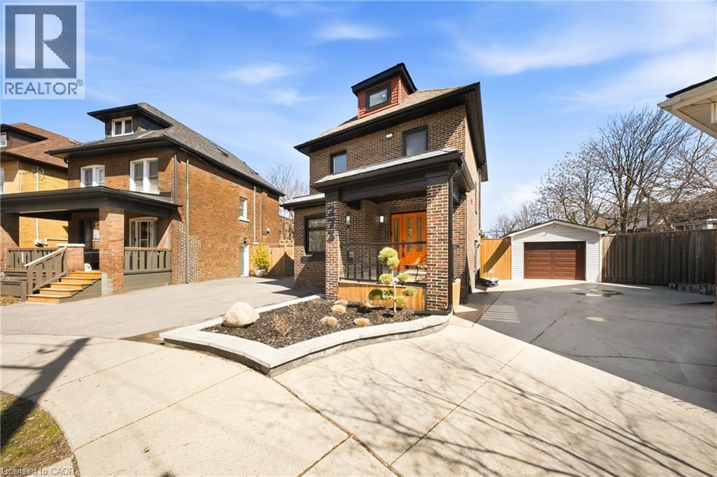 Traditional style home featuring an outdoor structure, a detached garage, brick siding, and concrete driveway - 273 Stinson Crescent, Hamilton, ON