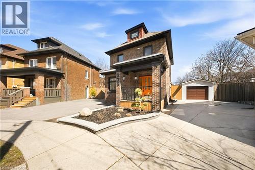 Traditional style home featuring an outdoor structure, a detached garage, brick siding, and concrete driveway - 273 Stinson Crescent, Hamilton, ON 