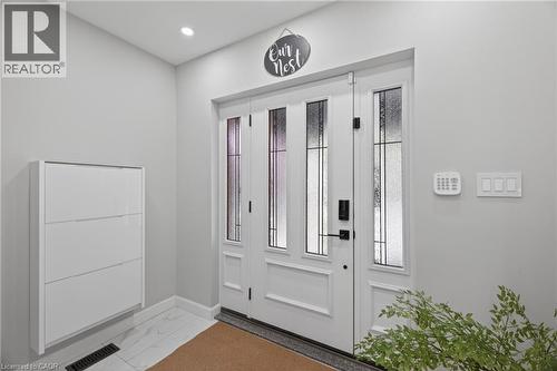 Entryway featuring a white door with frosted glass panels, matte black hardware, and a digital keypad - 273 Stinson Crescent, Hamilton, ON 