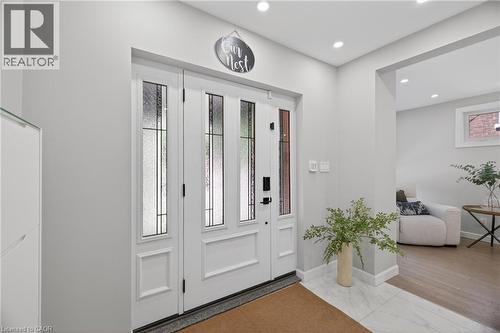 Bright entryway featuring a white paneled door with frosted glass inserts, recessed lighting, and a white tile floor - 273 Stinson Crescent, Hamilton, ON 