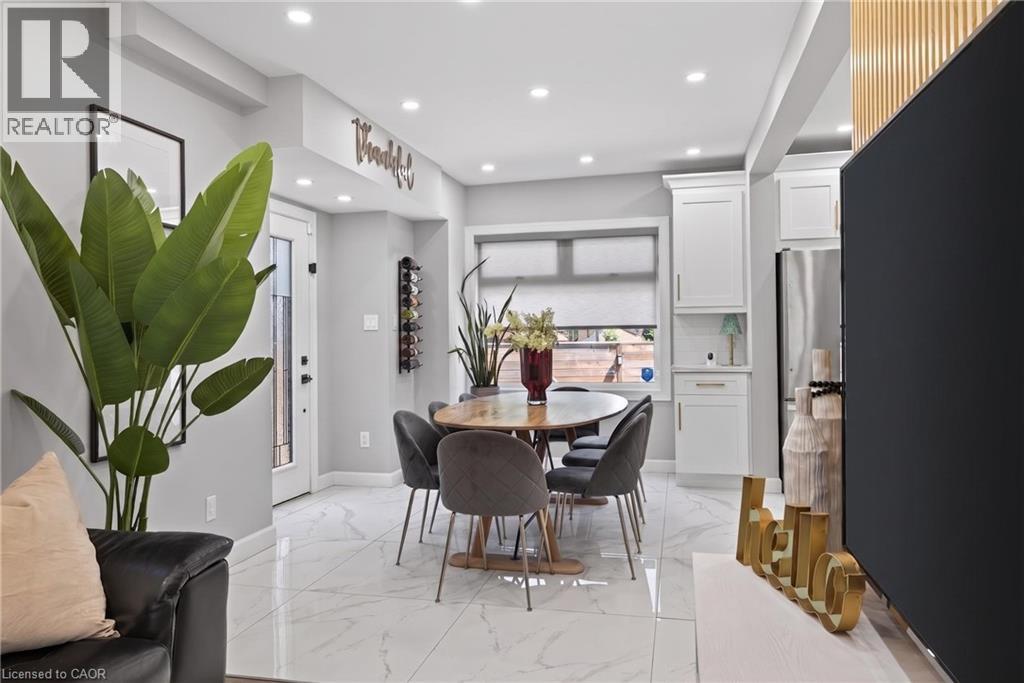 Dining area featuring marble-finish tile flooring, recessed lighting, and a built-in wine rack - 273 Stinson Crescent, Hamilton, ON