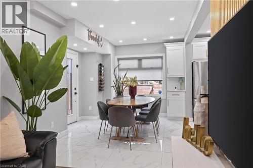 Dining area featuring marble-finish tile flooring, recessed lighting, and a built-in wine rack - 273 Stinson Crescent, Hamilton, ON 