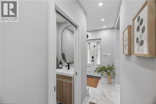 Entryway featuring a white paneled front door with glass inserts, recessed lighting, and large format marble-look floor tiles - 273 Stinson Crescent, Hamilton, ON 