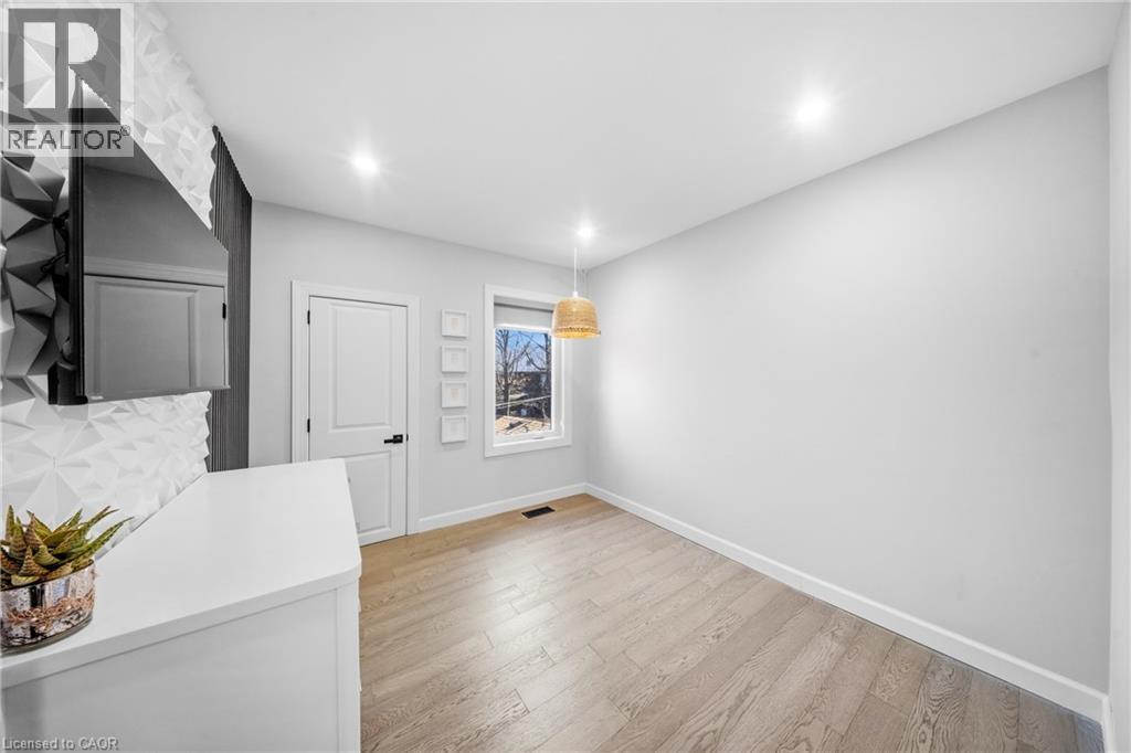 Unfurnished dining area featuring baseboards and light wood finished floors - 273 Stinson Crescent, Hamilton, ON