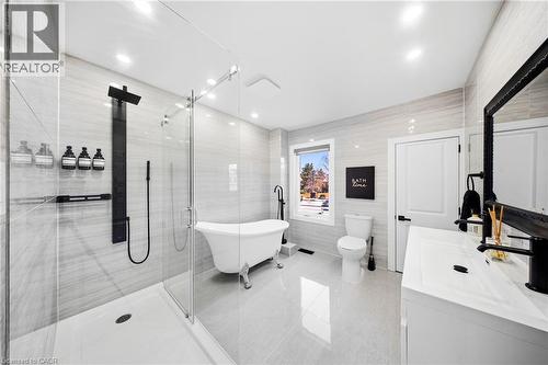 Bathroom with vanity, tile walls, a freestanding tub, a shower stall, and light tile patterned floors - 273 Stinson Crescent, Hamilton, ON 