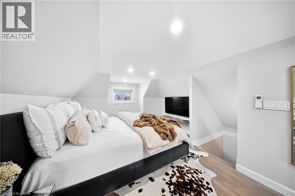 Bedroom featuring light wood-style flooring, lofted ceiling, and recessed lighting - 273 Stinson Crescent, Hamilton, ON