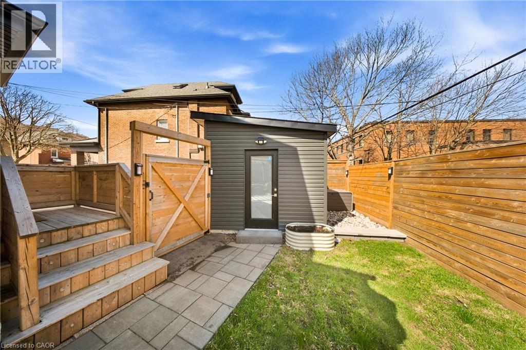 Rear view of house with a fenced backyard, a gate, and a wooden deck - 273 Stinson Crescent, Hamilton, ON