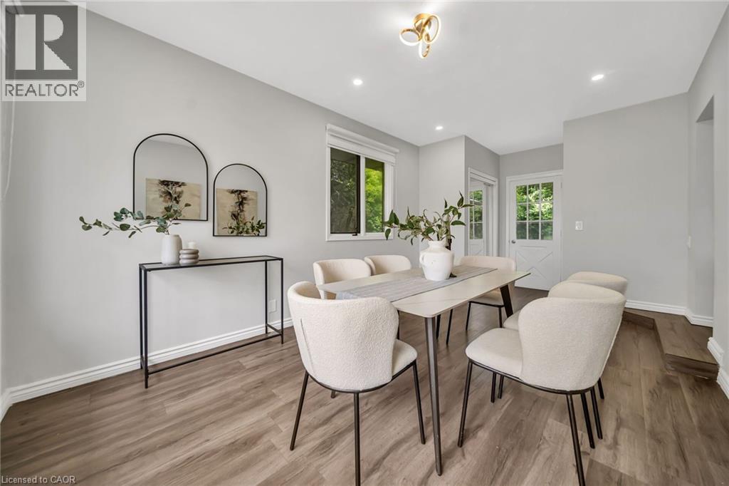 Wood-finish flooring, recessed lighting, contemporary ceiling light fixture, white trim, and a window with outdoor scenery - 284 Cedar Crescent, Cambridge, ON