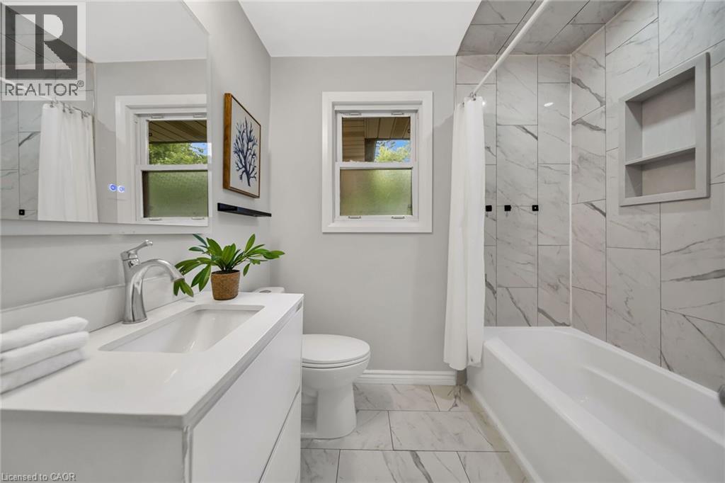 White floating vanity with an integrated sink, chrome faucet, and illuminated mirror - 284 Cedar Crescent, Cambridge, ON