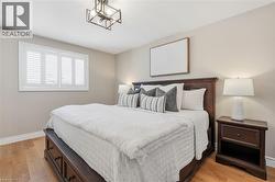 Wood-finish flooring, white window shutters, and a dark-toned ceiling light fixture -