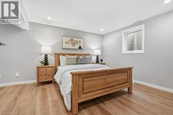 Recessed lighting, wood-finish flooring, light grey wall paint, and a window with blinds -