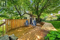 Expansive wood deck with built-in bench seating, surrounded by mature trees -