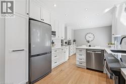 Kitchen featuring white cabinetry, stainless steel appliances, wood-finish flooring, recessed lighting, and a subway tile backsplash -