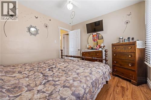Wood-finish flooring, ceiling fan, white paneled door, window with horizontal blinds - 625 Tate Avenue, Hamilton, ON 