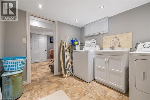 Recessed lighting, tile flooring, utility sink with storage, tile backsplash, and window blinds - 625 Tate Avenue, Hamilton, ON 