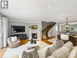 Hardwood flooring, fireplace with mantel, curved staircase with wrought iron railing, recessed lighting, and crown molding - 