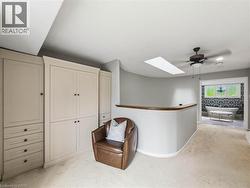 Built-in cabinetry with integrated drawers, skylight, ceiling fan, curved architectural wall, and a separate space with a freestanding bathtub - 