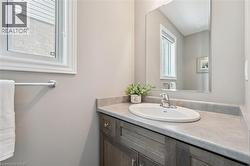 Vanity with built-in sink, gray countertop, and wood-finish cabinetry - 