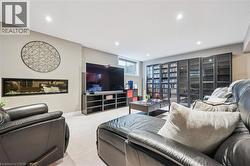 Built-in linear fireplace, recessed lighting, wall-to-wall built-in display cabinetry with glass doors, and light-toned carpet flooring - 