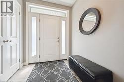 Entryway with a white paneled door, frosted glass sidelights, and a transom window - 
