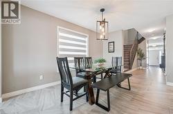 Dining area with a linear pendant light fixture, featuring a window with layered shades, and wood-finish tile flooring - 