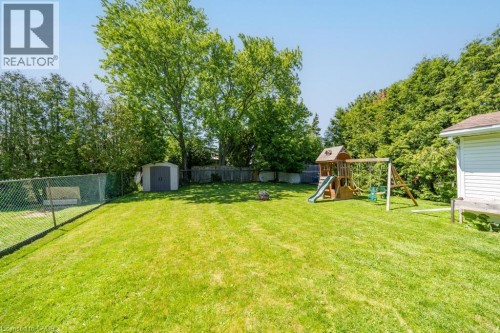 Expansive green lawn with mature trees and a chain-link fence - 420 Upper Gage Avenue, Hamilton, ON 