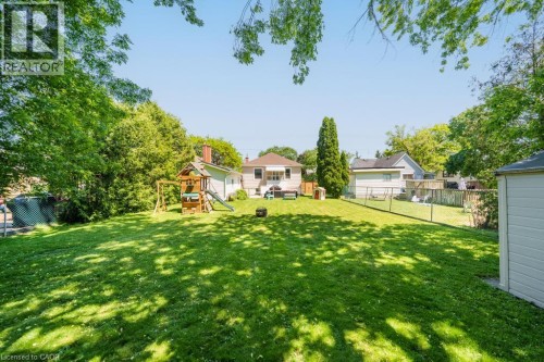 Expansive lawn area, mature trees, and a low-profile chain link fence defining the property boundary - 420 Upper Gage Avenue, Hamilton, ON 
