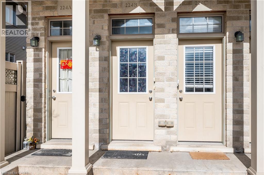 Brick facade with three distinct entry doors, each featuring an upper transom window and wall-mounted exterior lighting - 224 Jessica Crescent Unit# B, Kitchener, ON