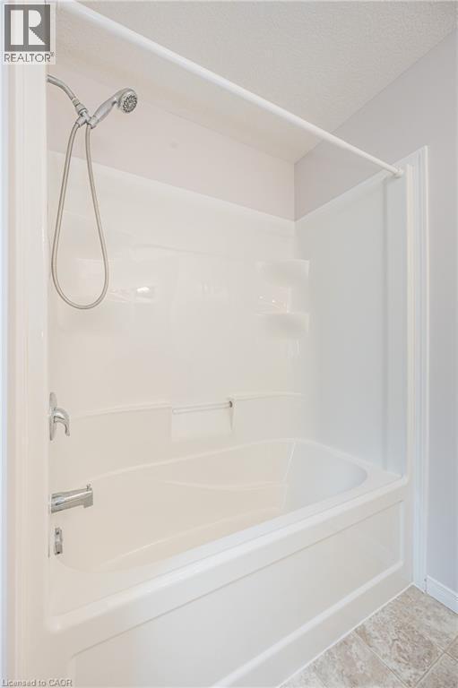 White fiberglass tub-shower combination with a handheld shower head and chrome fixtures - 224 Jessica Crescent Unit# B, Kitchener, ON